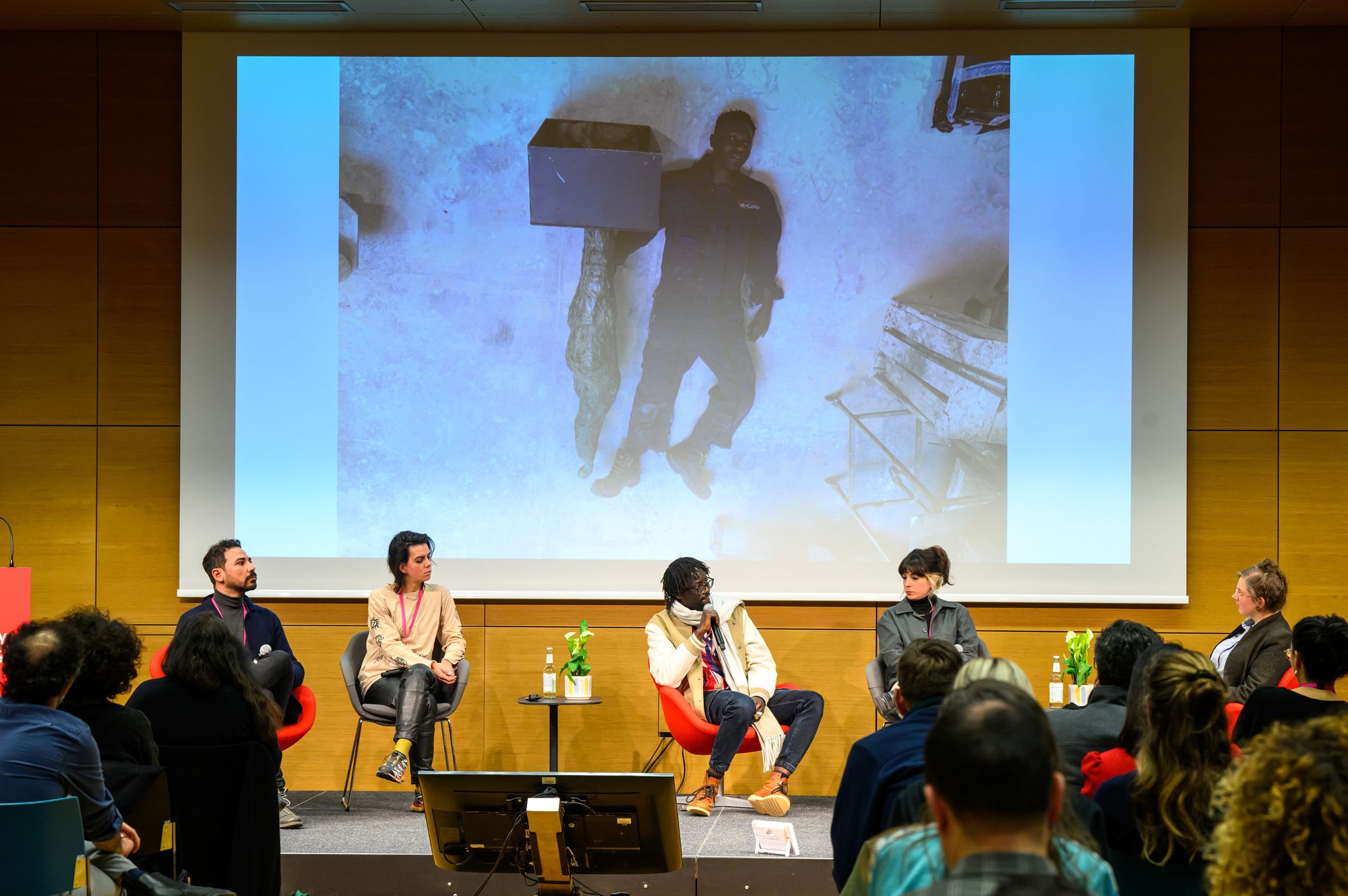 Mamadou Socrate Diop during his presentation, with a still from his project 